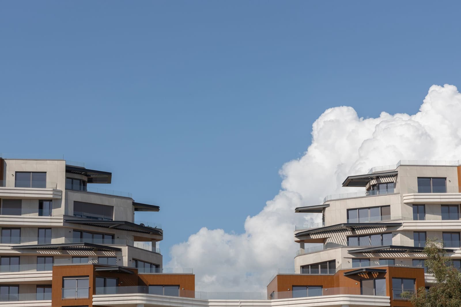 Edificio de obra nueva con terrazas bajo un cielo azul